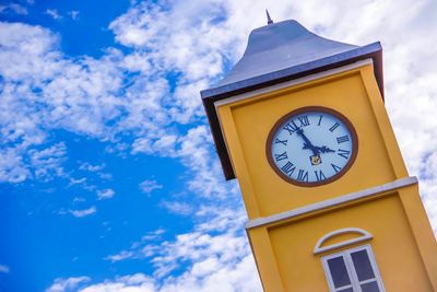 Low angle view of clock on building against sky