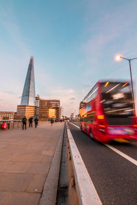 Blurred motion of bus by shard london bridge against sky at dusk