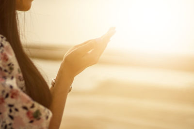 Woman praying hand on sunset