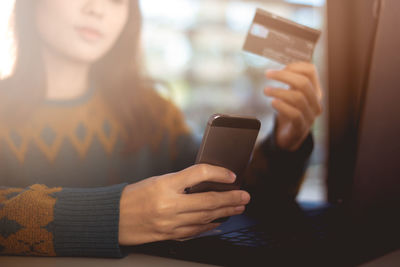 Midsection of woman using mobile phone