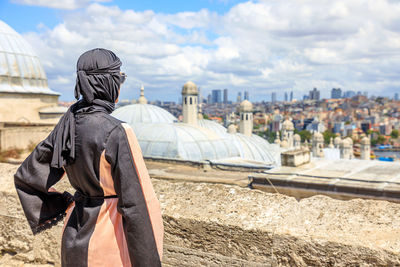 Rear view of man standing against buildings