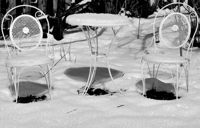 View of empty chairs on snow covered field