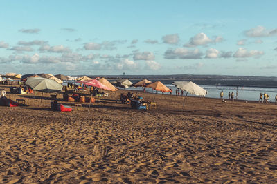 Group of people on beach against sky