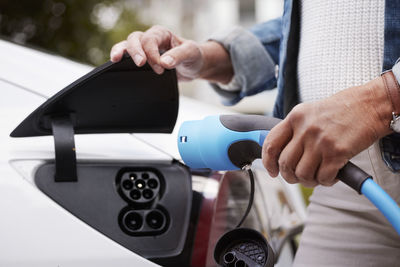 Woman charging electric car