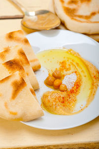 Traditional chickpeas hummus with pita bread and paprika on top