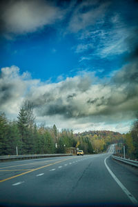 Empty road against cloudy sky