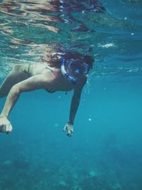 Full length of shirtless boy swimming in sea