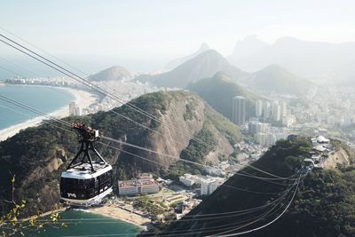 Overhead cable car over mountains against sky