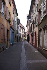 Empty narrow alley along buildings