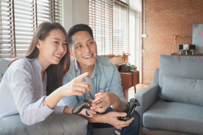 Young woman smiling while sitting on sofa