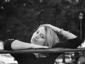 Portrait of young woman at railing outdoors