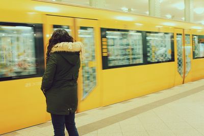 Rear view of woman standing at subway station