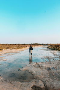 Portrait of woman standing in water against sky