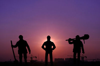 Silhouette people standing against sky during sunset