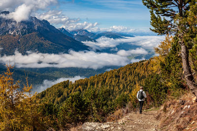 Rear view of woman hiking on trail at mountain