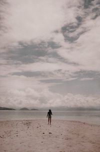 Mid distance of teenage girl standing against sea at beach