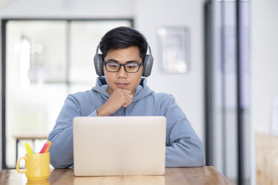 Young collage student using computer and mobile device studying