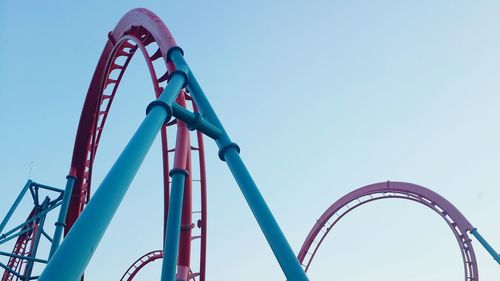 Low angle view of ferris wheel against clear blue sky