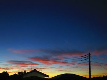 Silhouette electricity pylon against sky during sunset