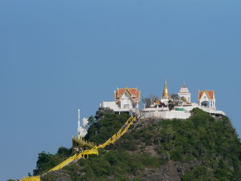 Built structure by building against clear blue sky