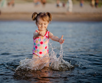 Cute girl playing in sea at beach