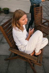 Side view of woman sitting on chair