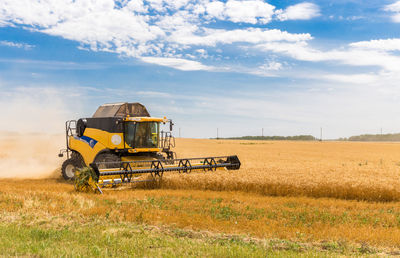 Tractor on agricultural field against sky