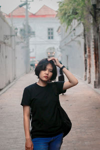 Portrait of young woman standing in city