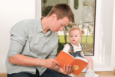 Boy using digital tablet while sitting on sofa at home