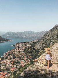 Rear view of woman looking at mountains against clear sky