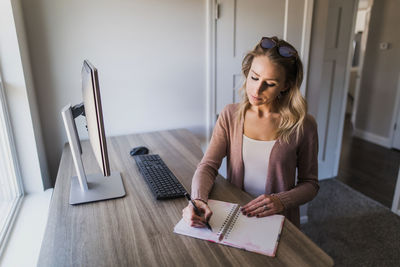 Woman sitting on table at home