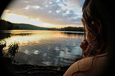 Portrait of woman in lake against sky during sunset