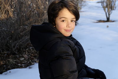 Portrait of smiling boy standing in snow