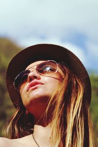 Low angle view of woman wearing sunglasses and hat