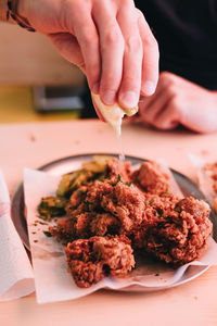 Close-up of person holding food on table