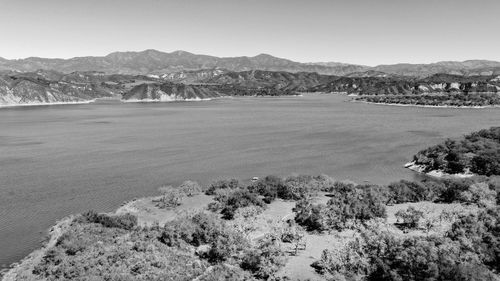 Scenic view of sea and mountains against clear sky