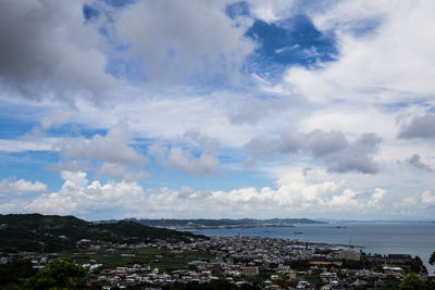 Aerial view of cityscape by sea against sky