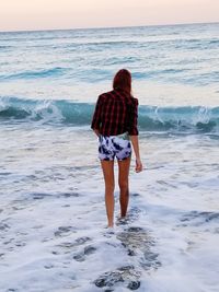 Rear view of man standing on beach