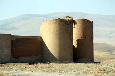 Abandoned built structure on field against sky