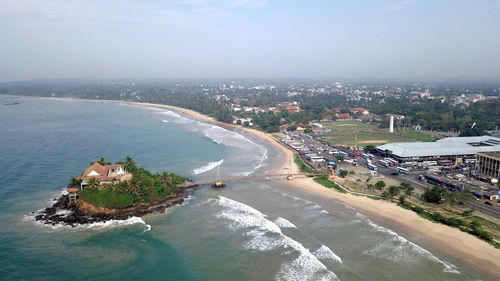 High angle view of buildings by sea against sky