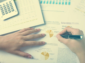 High angle view of woman reading book on table