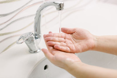 Woman washes her hands by surgical hand washing method.