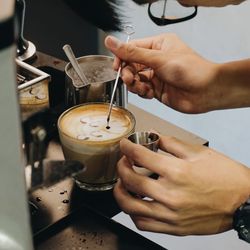 Cropped image of man preparing coffee in cafe