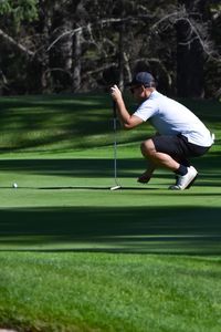 Full length of man crouching on golf course