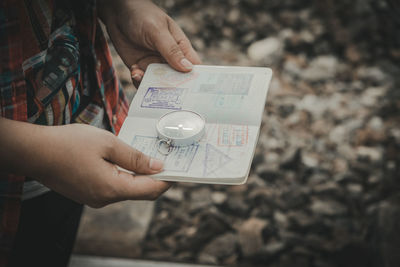 Midsection of person holding paper