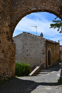 Stone wall of old building against sky