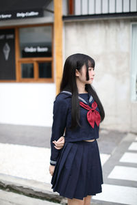 Full length of woman standing against wall