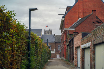 Footpath amidst buildings against sky