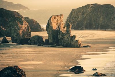 Rock formations by sea against sky