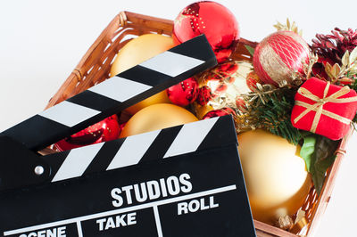 Close-up of film slate and baubles on white background